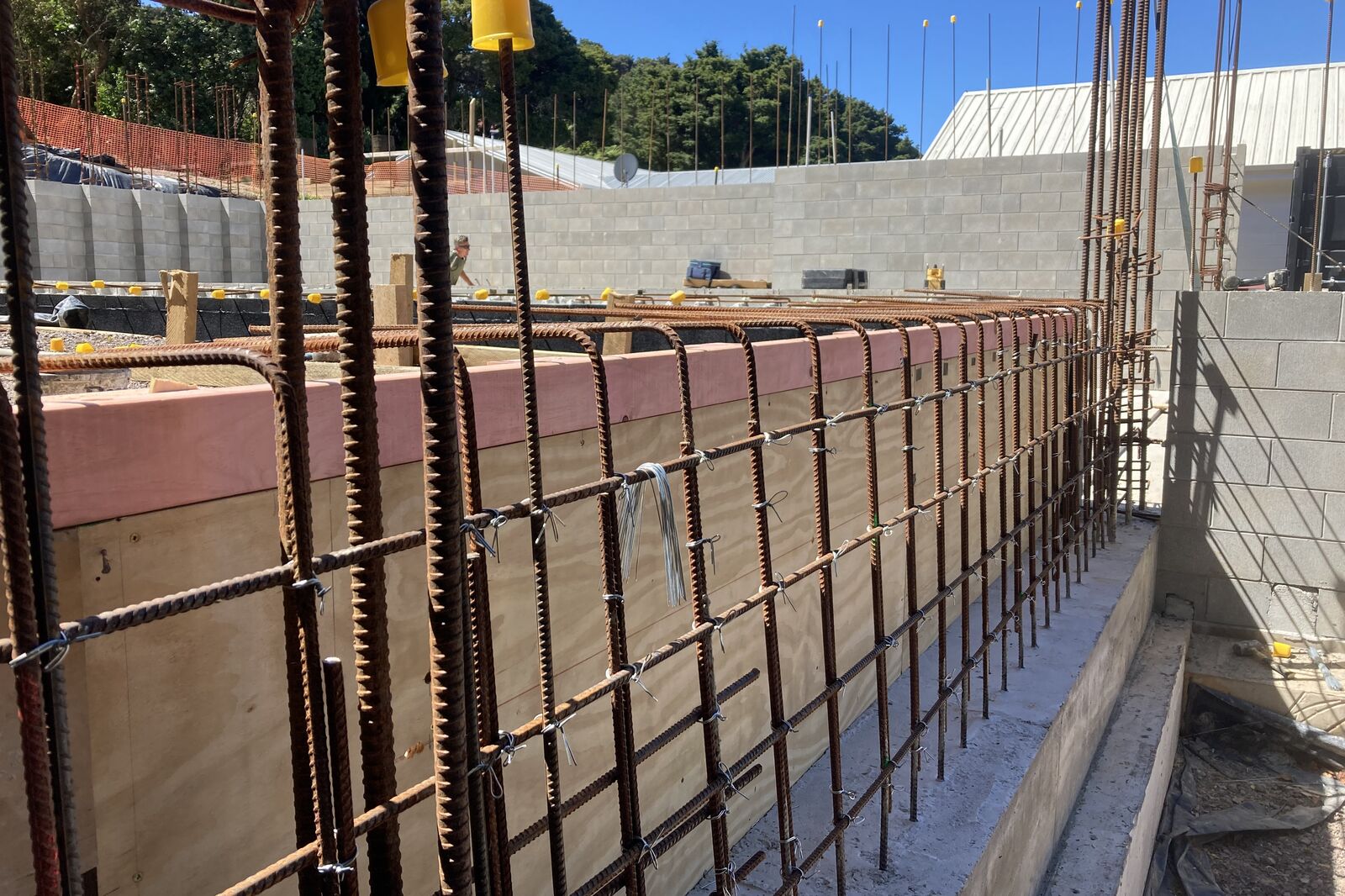 Steel reinforcing and boxing for a concrete foundation beside new block walls