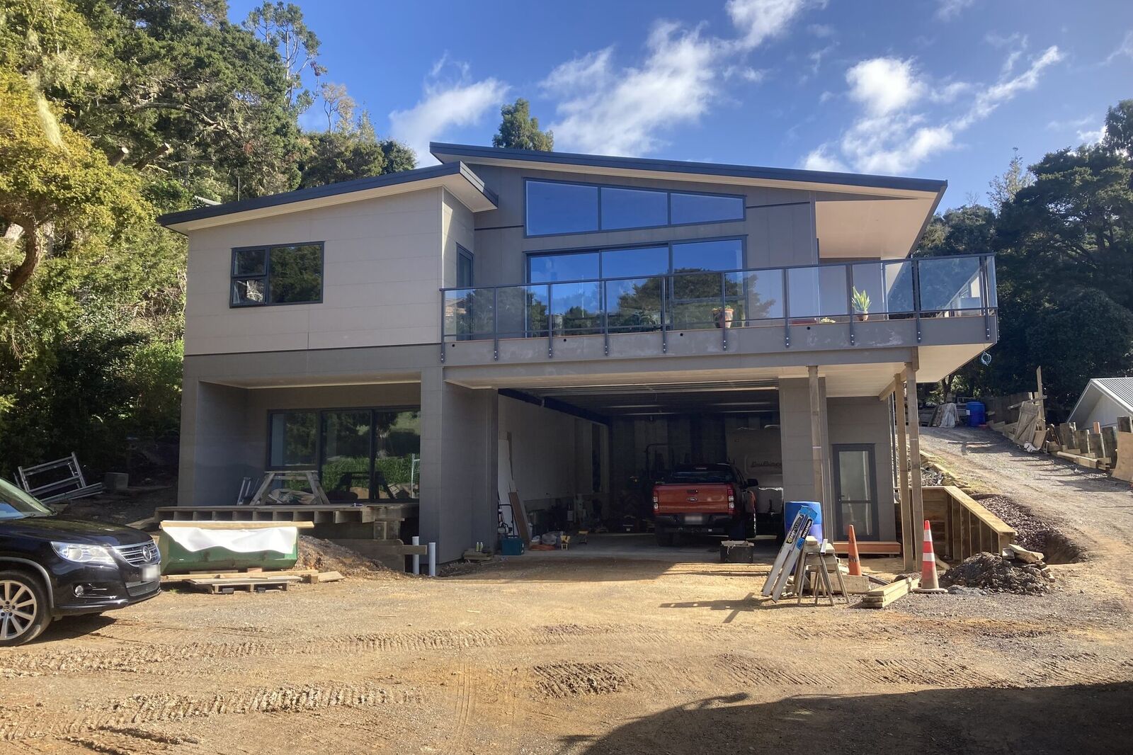 Two-storey home with a glass balcony, nearing completion