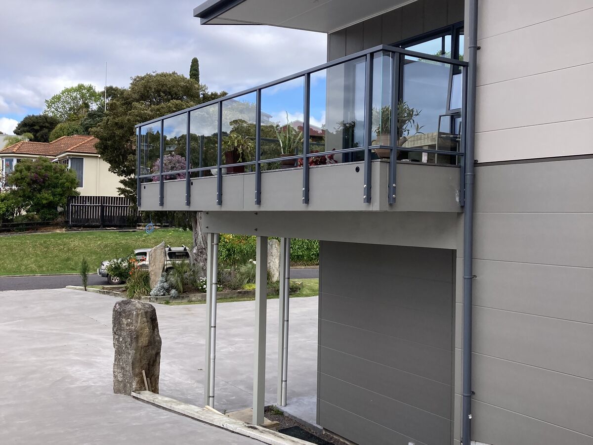 Glass balustrade balcony on steel posts over the drive