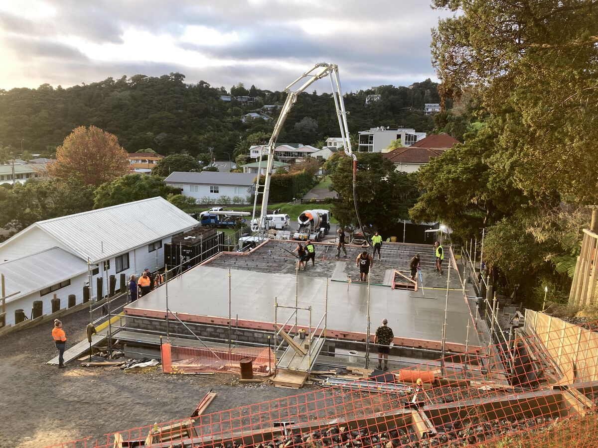 The crew screeding a fresh concrete slab pour