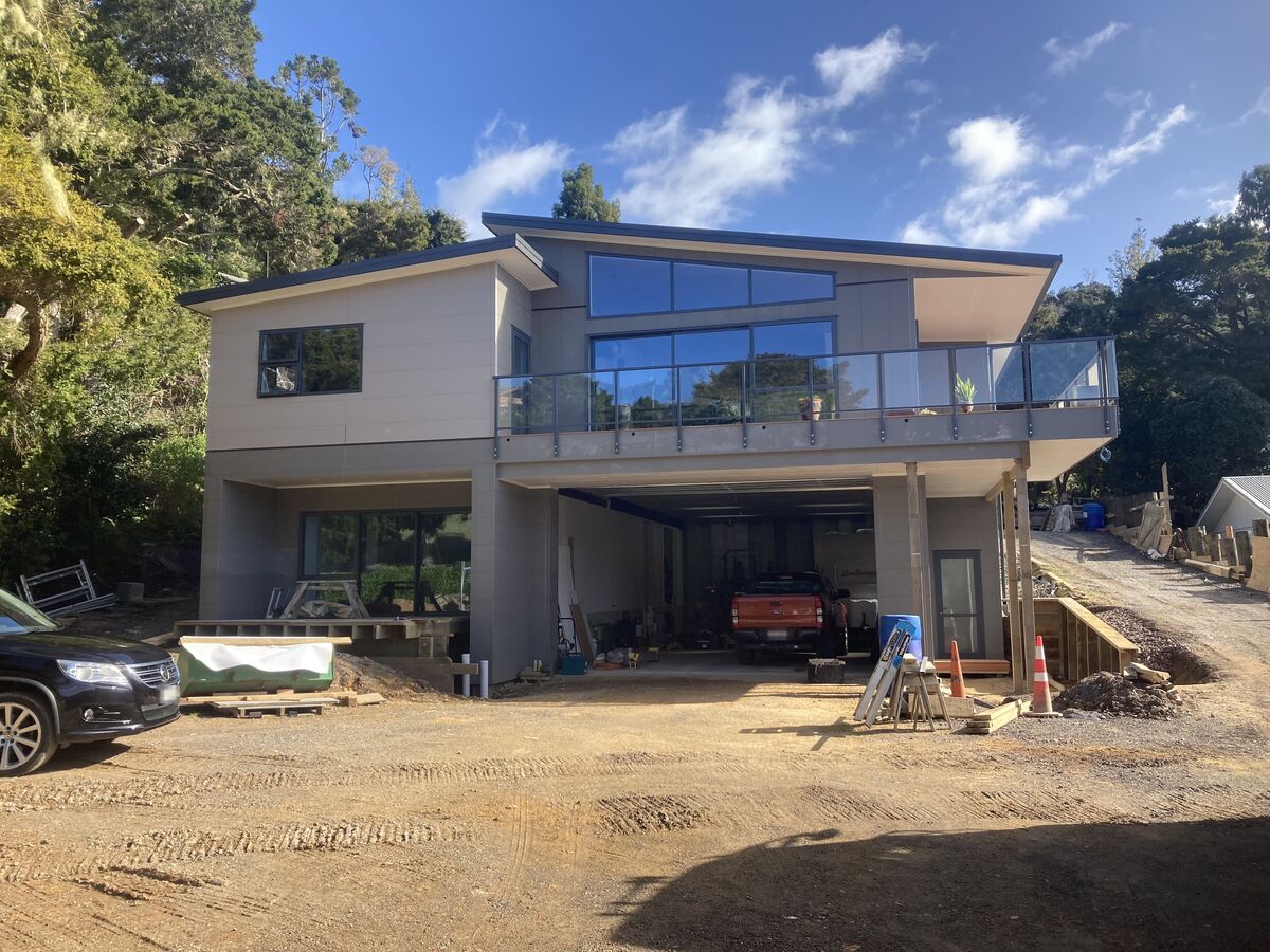 Two-storey home with a glass balcony, nearing completion